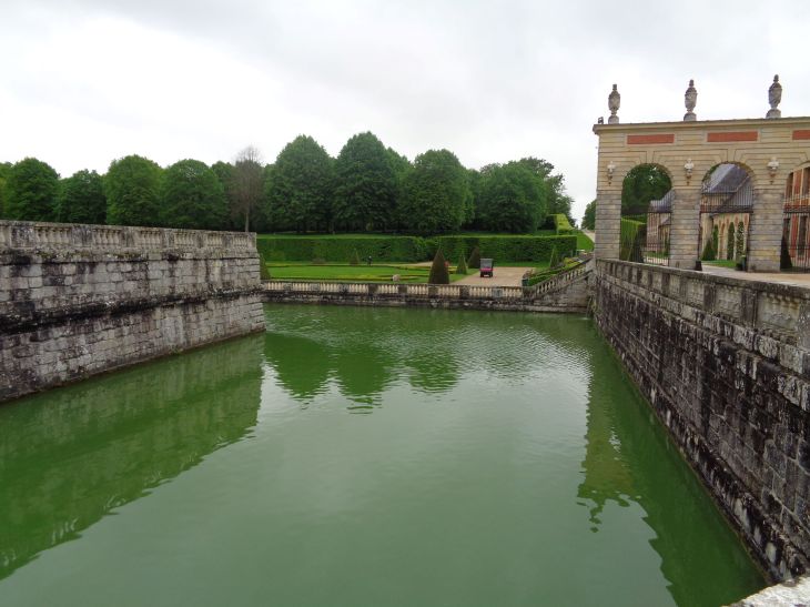 Vaux le Vicomte castle crossing moats with carriage museum on right may23